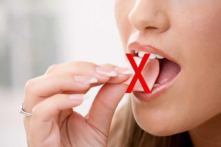 Woman putting chewing gum in her mouth